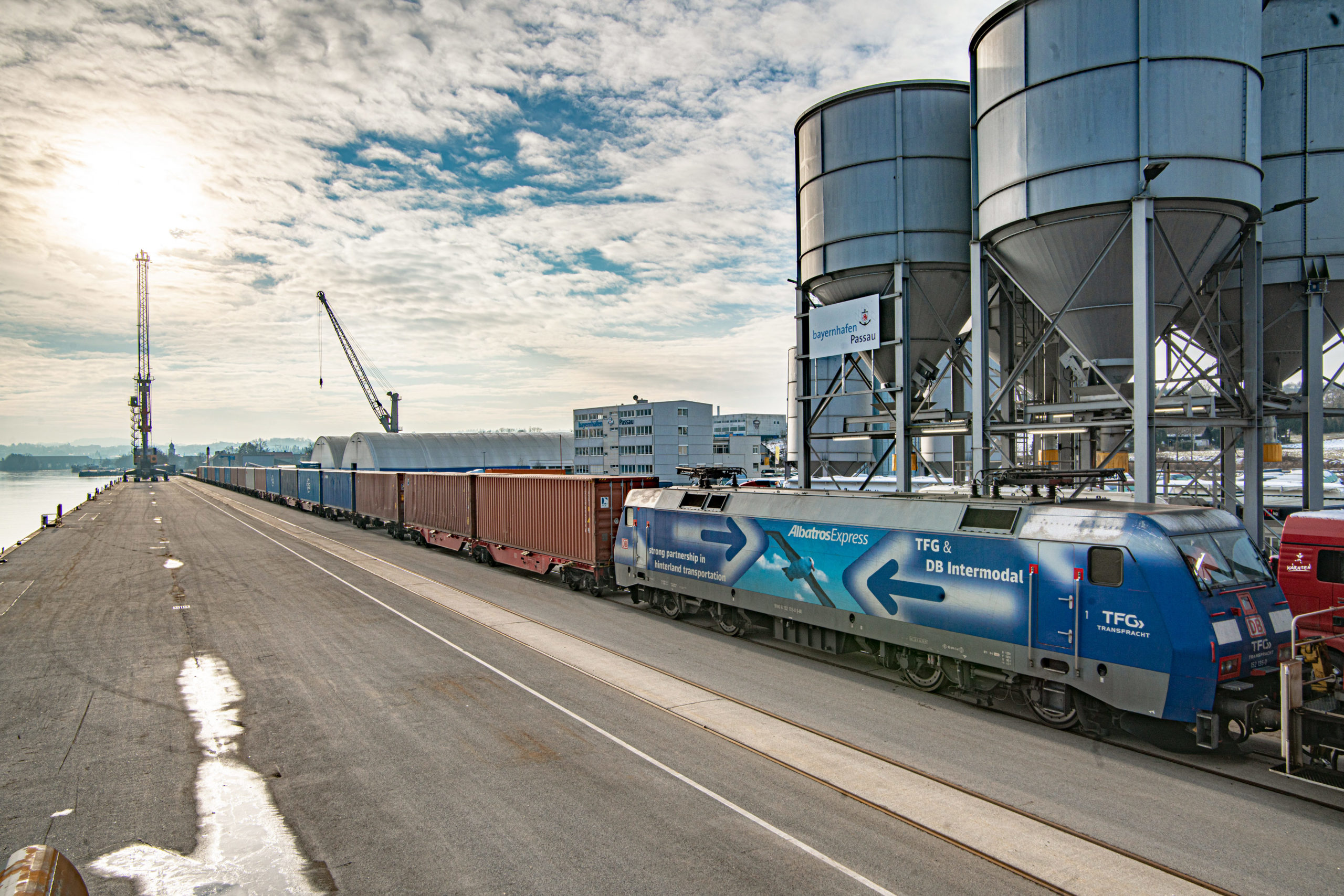 Intermodal-Containerzug am Kai des bayernhafen Passau, im Hintergrund Silos und Hafenkran