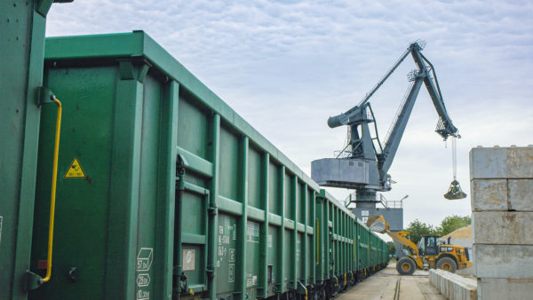 heeled loaders and port cranes load earths into green rail cars at bayernhafen Aschaffenburg