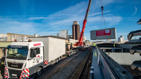 Loading of prefabricated concrete garages from trucks on to barge at bayernhafen Bamberg