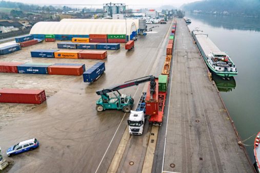 Luftbild Hafenbetrieb bayernhafen Passau mit Binnenschiff, Containerzug